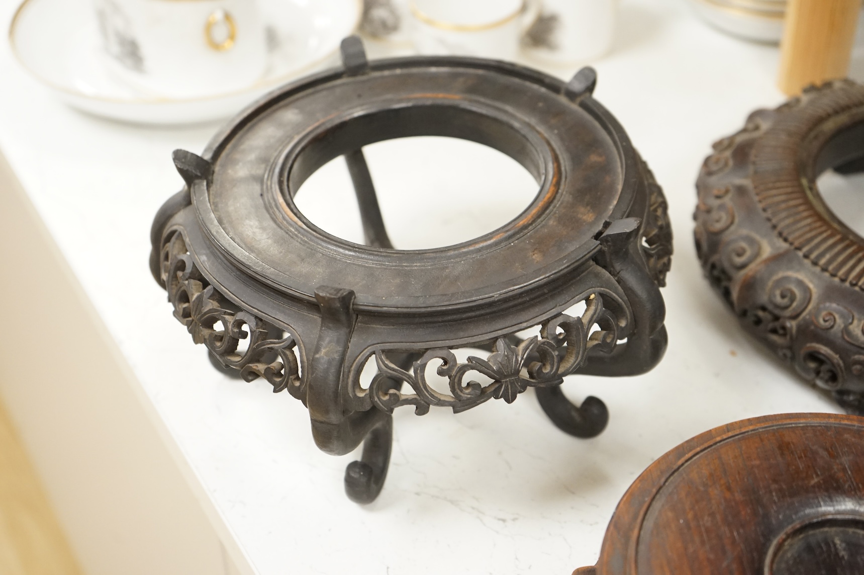 A collection of five Chinese and Japanese carved hardwood stands, late 19th/early 20th century, largest 25cm in diameter